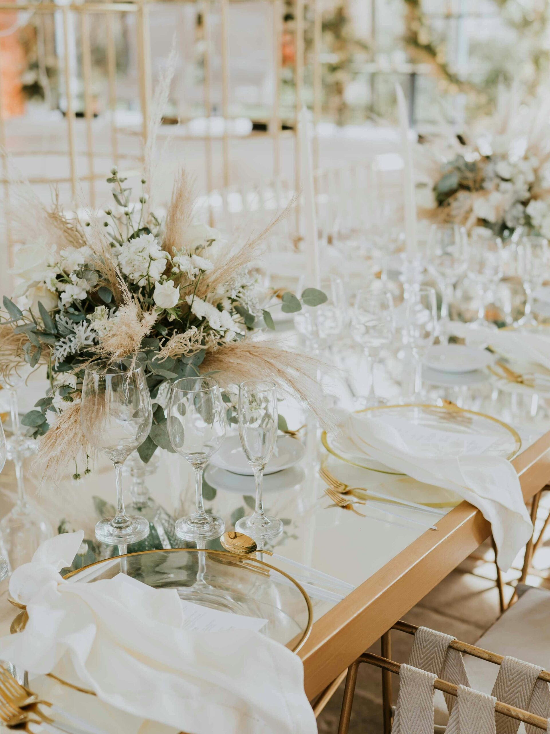 gold wedding reception table with white floral arrangements